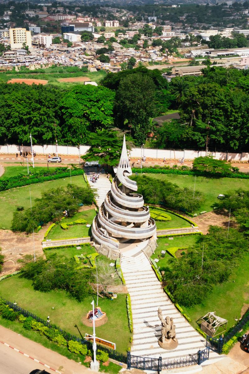 Success Stories A stunning aerial shot of the Reunification Monument surrounded by greenery in Yaoundé, Cameroon.